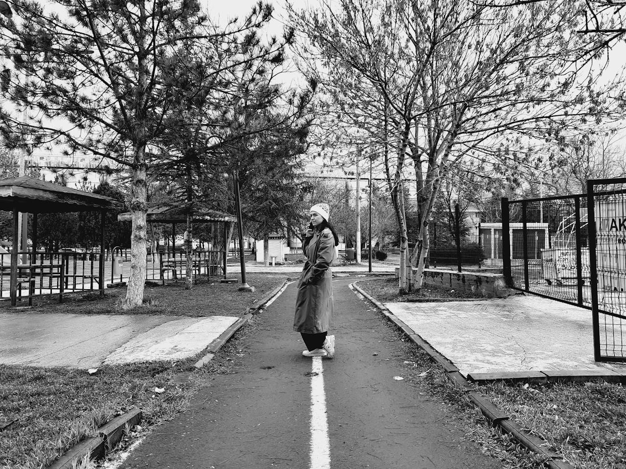 hero-img-01 Black and white photo of a woman in a park on a winter day, creating a moody atmosphere.